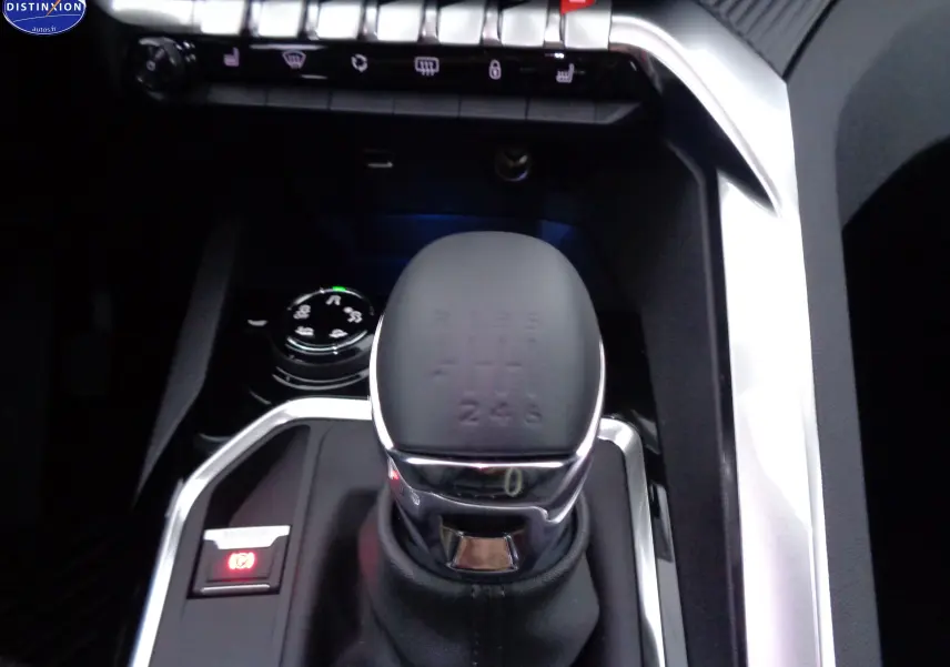 Gros plan sur le levier de vitesse automatique et les commandes du tableau central d'un Peugeot 3008 noir perle métal.