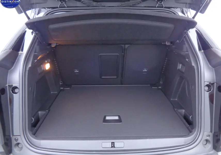 Coffre ouvert du Peugeot 3008 noir perle métal, vue arrière montrant un espace de chargement spacieux et bien éclairé.