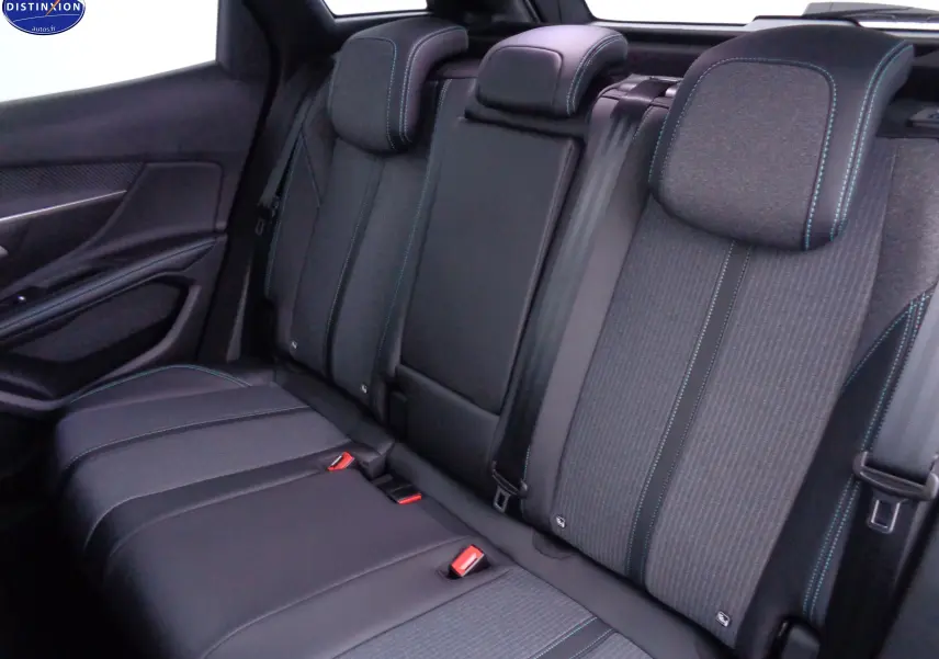Vue intérieure arrière du Peugeot 3008 2023, sièges noirs en cuir et tissu avec surpiqûres bleues contrastantes.