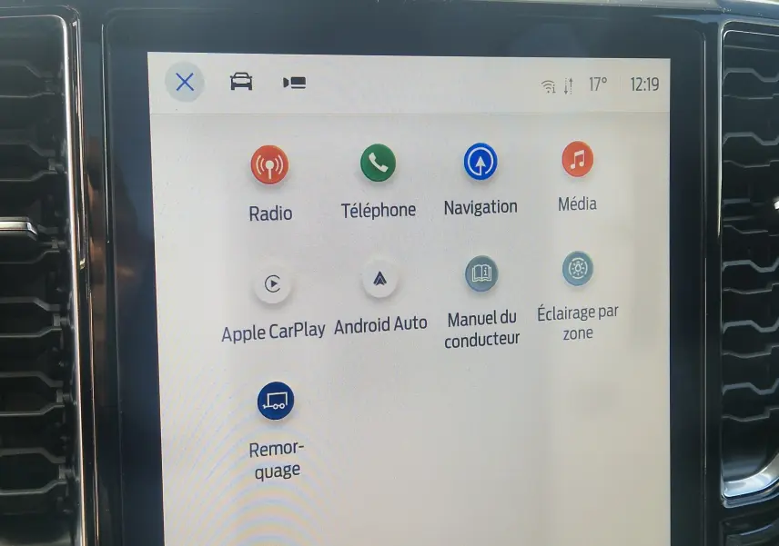 Gros plan sur les commandes de climatisation et volume du Ford Ranger Super Cabine Wildtrak 2025 gris Iconic.