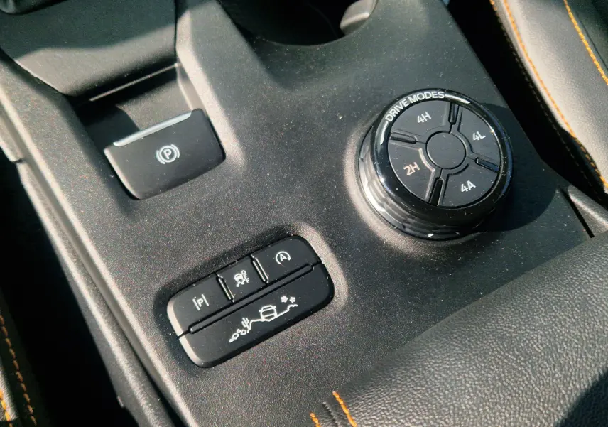 Vue rapprochée de la console centrale ouverte et des sièges en cuir noir avec surpiqûres orange du Ford Ranger Wildtrak 2025.