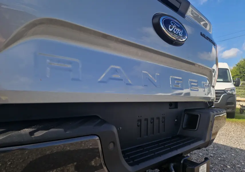 Gros plan sur l'arrière gris iconique du Ford Ranger Super Cabine 2025, mettant en valeur le logo et la benne robuste.