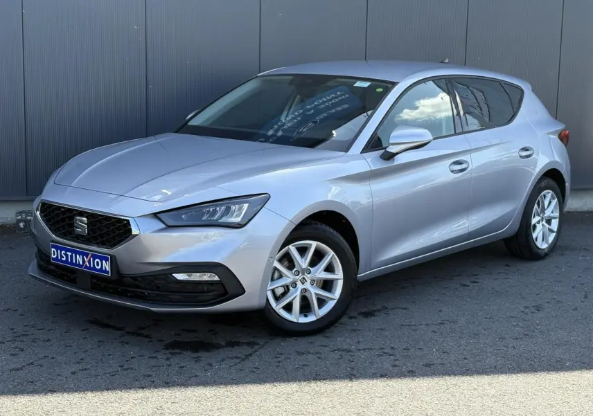 SEAT Leon 2024 gris argent vue 3/4 avant droit avec jantes alliage et vitres arrière surteintées.