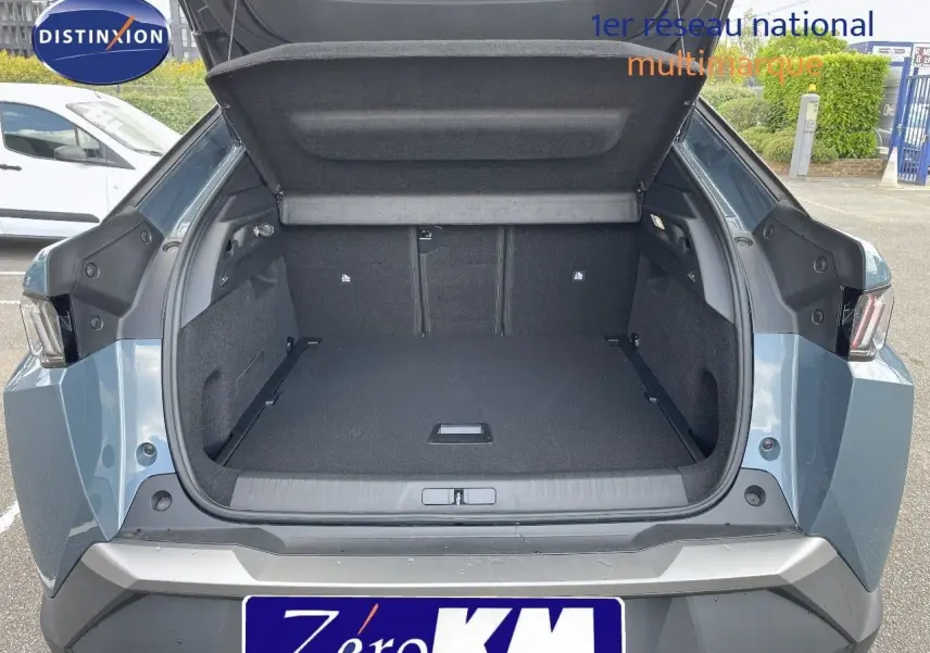 Coffre ouvert vu de l'arrière d'un Peugeot 3008 Hybrid 136ch Allure bleu Ingaro Metal, montrant un espace de chargement spacieux.