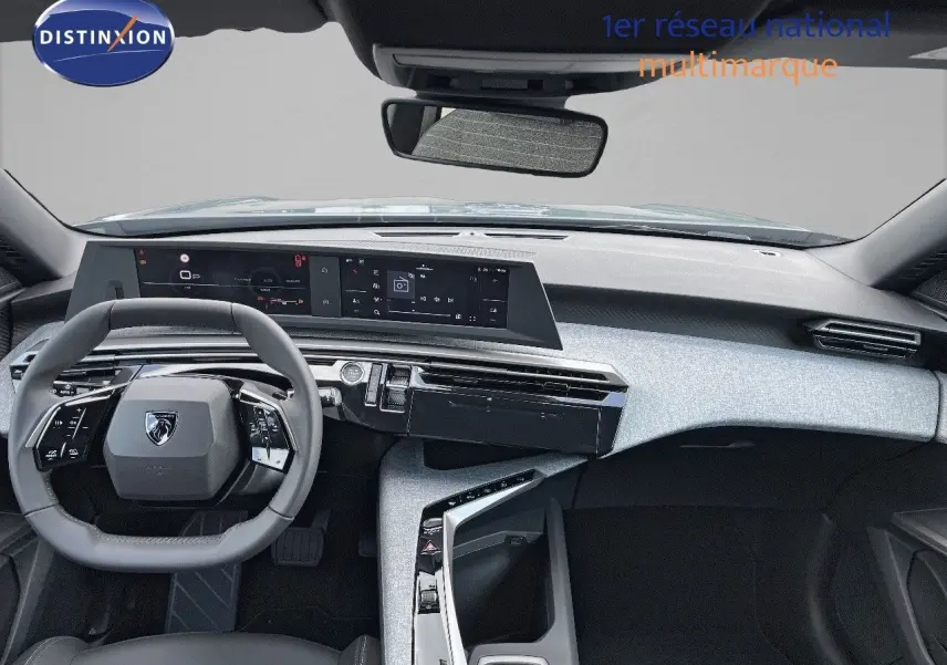 Vue intérieure avant du Peugeot 3008 Hybrid 2025 avec tableau de bord moderne et volant compact noir.