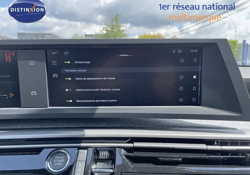 Vue rapprochée de l'écran tactile et console centrale du Peugeot 3008 Hybrid 2025 avec commandes modernes et finition noire brillante.