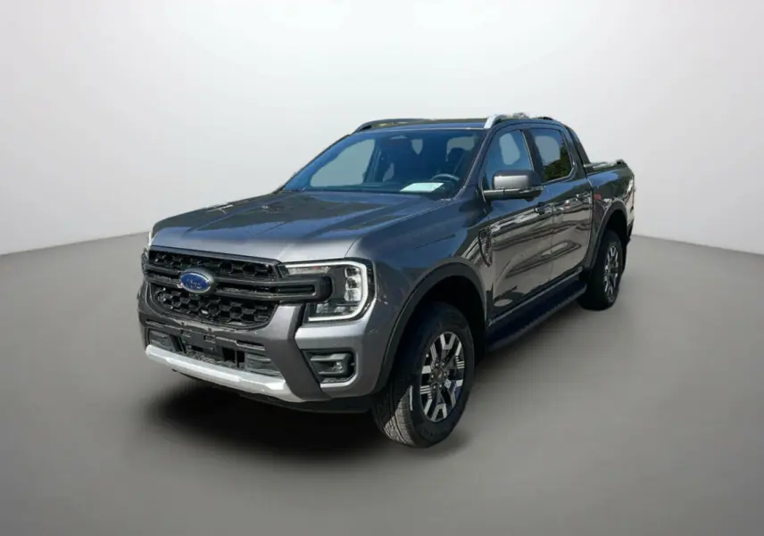 Ford Ranger 2025 gris carbone en vue 3/4 avant droit, avec calandre imposante et jantes alliage distinctives Wildtrak Plus.