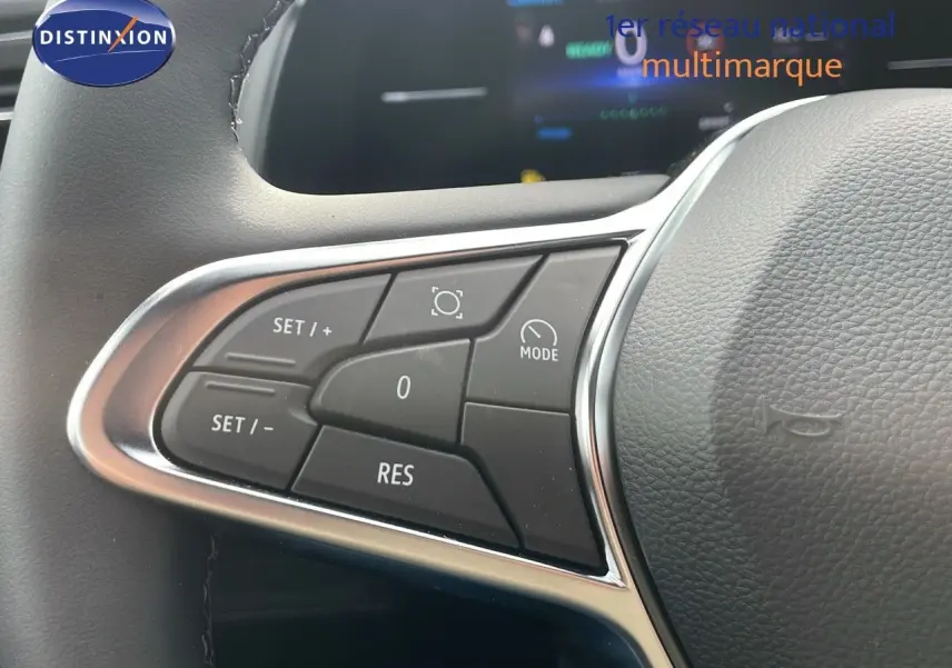 Gros plan sur les commandes de régulateur de vitesse au volant d'un Renault Captur gris Cassiopée 2025.