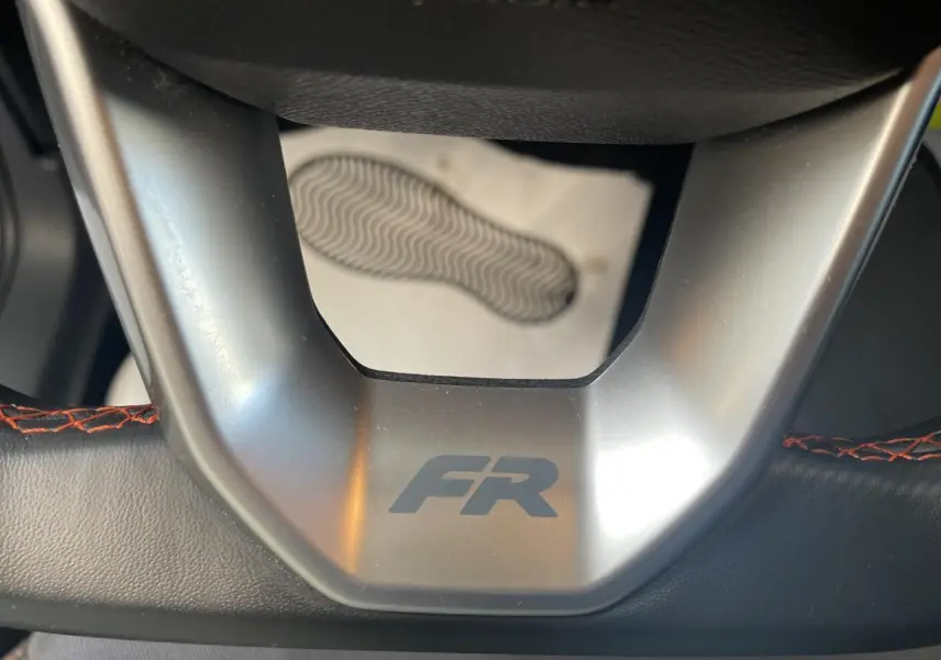 Gros plan sur le volant sport cuir noir avec surpiqûres rouges et logo FR de la SEAT Arona 2024.