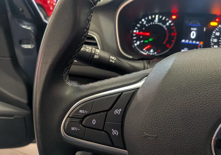 Gros plan sur le volant de la Renault Mégane IV Berline 2022, montrant les commandes de régulateur de vitesse.
