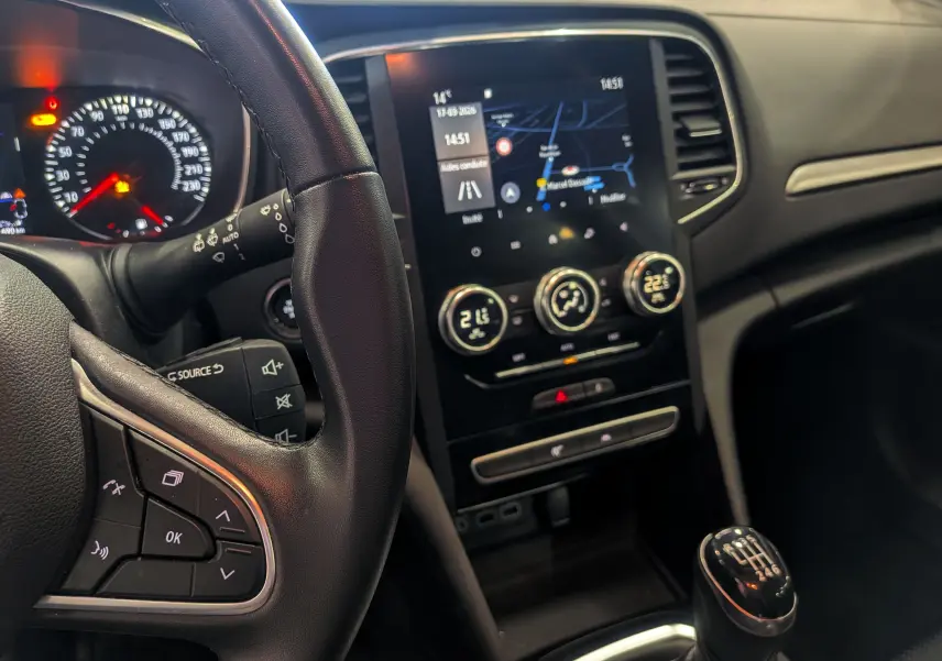 Vue intérieure de la Renault Mégane IV Business 2022, volant cuir noir, écran tactile et levier de vitesses manuel.