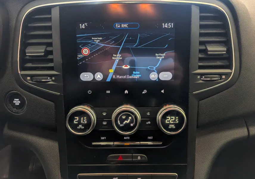 Vue rapprochée du tableau de bord de la Renault Mégane IV Business 2022, écran tactile avec navigation et commandes de climatisation.