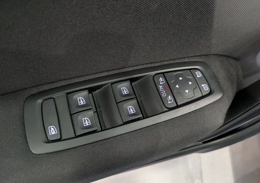 Commande des vitres et rétroviseurs sur la porte côté conducteur d'une Renault Mégane IV Berline gris Titanium, intérieur tissu noir.