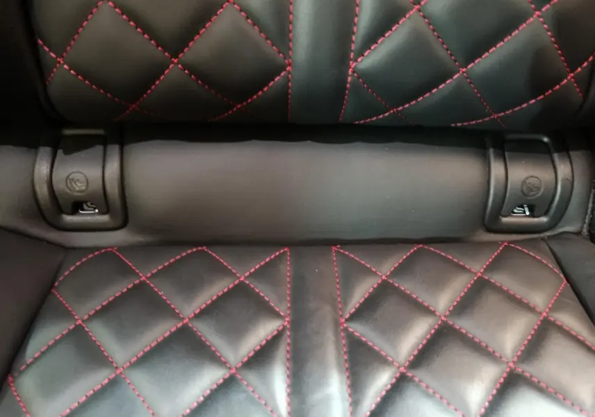 Détail de la sellerie arrière en cuir noir avec surpiqûres rouges du Audi Q5 hybride rechargeable 2023.