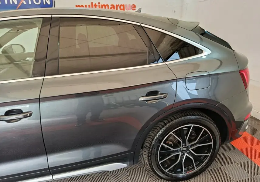 Vue latérale droite d’un Audi Q5 gris clair 2023 hybride rechargeable avec jantes alliage noires et détails chromés.