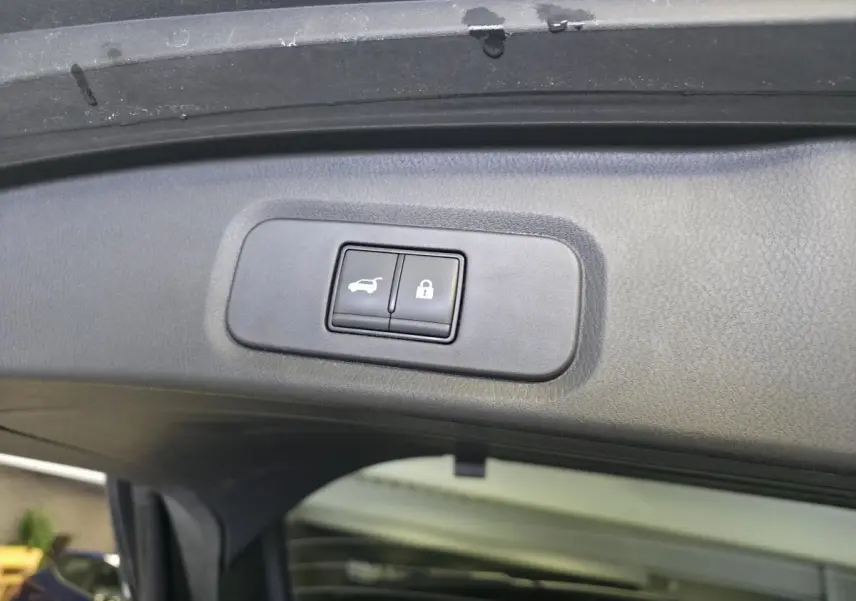 Gros plan sur les boutons d'ouverture et de verrouillage du hayon électrique du Nissan Qashqai gris 2024.