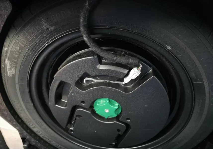 Gros plan sur la roue de secours temporaire noire du Nissan Qashqai 1.5 e-Power gris 2024, avec câble électrique visible.