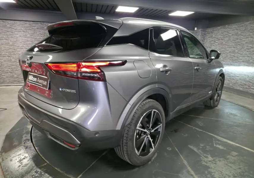 Vue 3/4 arrière droite du Nissan Qashqai 1.5 e-Power gris métallisé avec toit panoramique et jantes alliage 19 pouces.