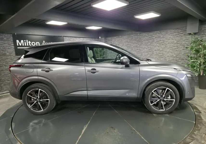 Vue de profil côté gauche d'un Nissan Qashqai gris métallisé avec jantes alliage 19 pouces et badge e-Power visible.