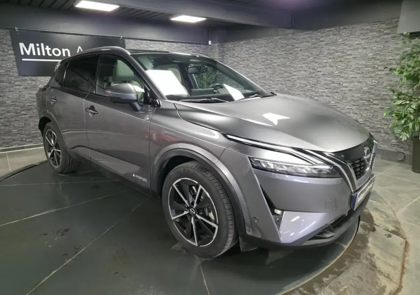 Nissan Qashqai 1.5 e-Power gris métallisé en vue 3/4 avant droit avec toit panoramique et jantes alliage 19 pouces.