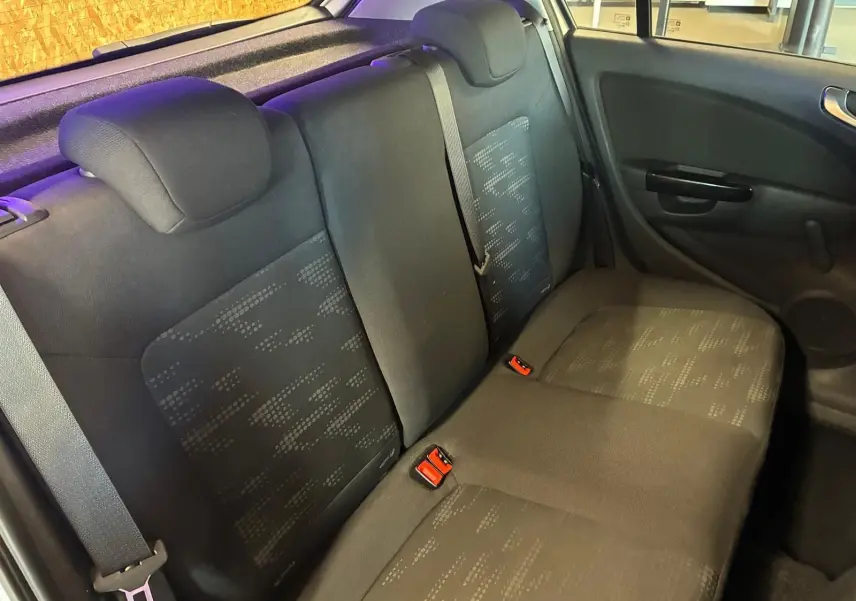 Vue intérieure montrant la banquette arrière en tissu noir de l'Opel Corsa gris clair, côté droit avec ceinture de sécurité.