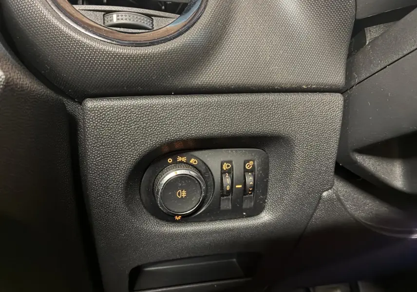 Gros plan sur le panneau de commande des phares et éclairages intérieurs d’une Opel Corsa gris clair, intérieur noir.