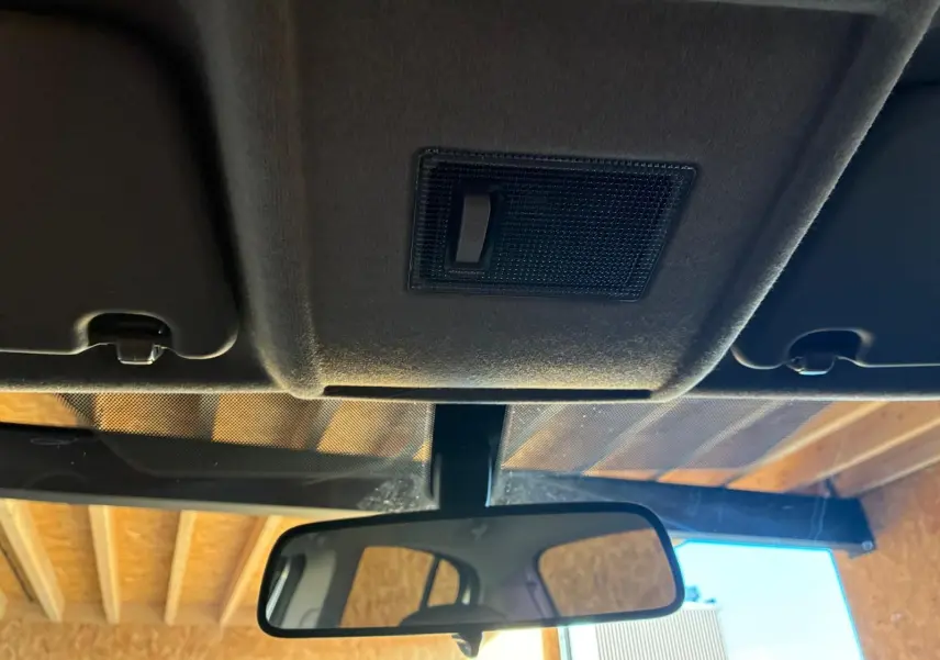 Vue intérieure centrée sur le rétroviseur et le plafonnier d'une Opel Corsa gris clair de 2012.