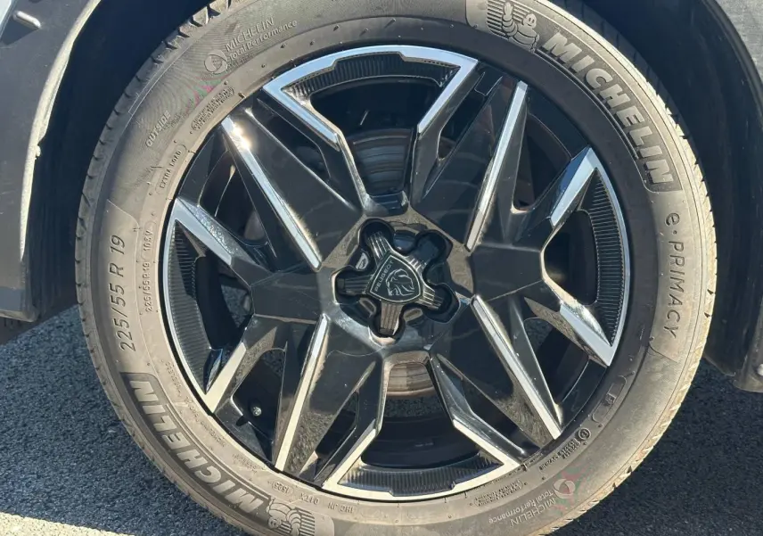 Gros plan sur la jante alu noire et argentée du côté gauche d’un Peugeot 5008 blanc Okénite.