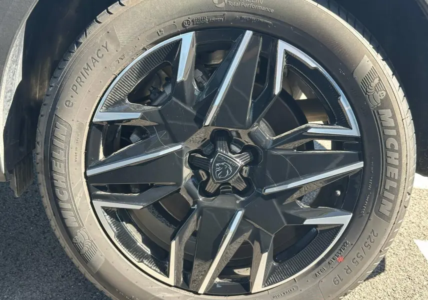 Gros plan sur la jante noire et argentée Michelin du côté gauche du Peugeot 5008 blanc Okénite.