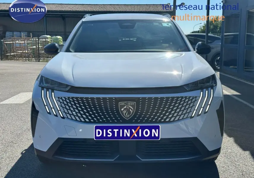 Vue avant d'un Peugeot 5008 Hybrid blanc Okénite avec calandre distinctive et feux LED en griffes.