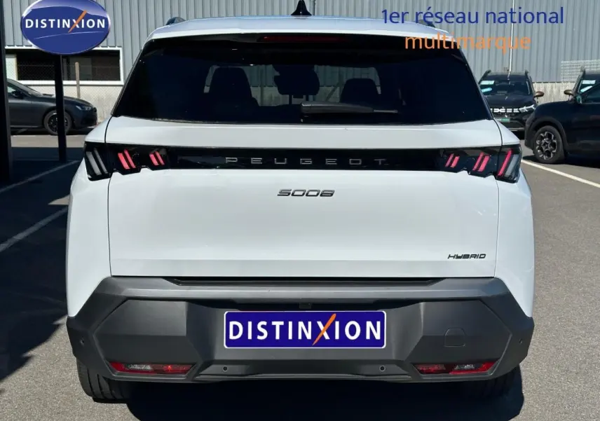 Vue arrière d'un Peugeot 5008 Hybrid blanc Okénite avec feux LED distinctifs et logo Peugeot noir.