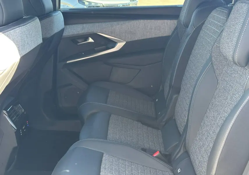 Vue côté droit des sièges arrière gris tissu et cuir du Peugeot 5008 Hybrid 2025 avec accoudoir central rabattable.