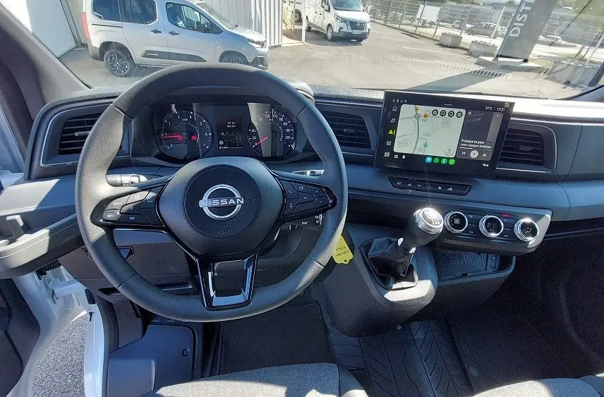 Vue intérieure du tableau de bord du Nissan Interstar Fourgon blanc 2025, volant multifonction et écran tactile avec navigation.