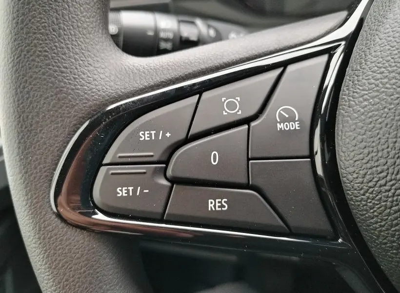 Gros plan sur les commandes noires au volant du Nissan Interstar Fourgon blanc, version 2026, avec boutons de réglage de vitesse et mode.
