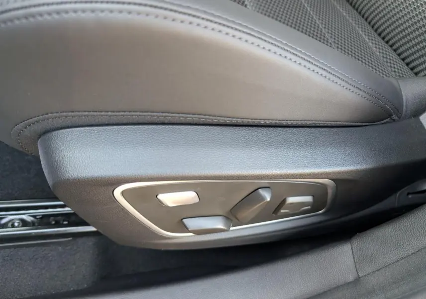 Gros plan sur les commandes électriques du siège conducteur en sellerie mixte tissu carbone Alcantara gris.