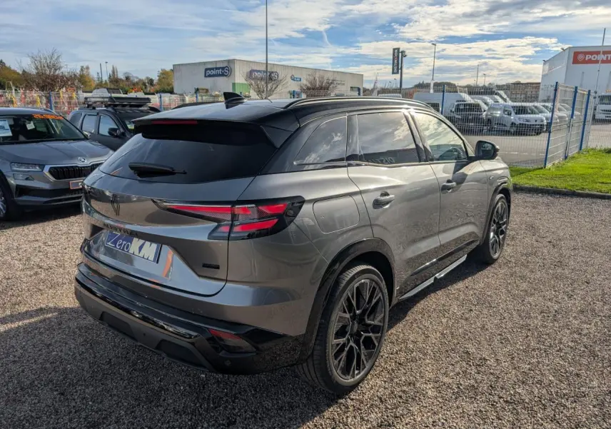 Vue 3/4 arrière droite du Renault Austral gris métallisé avec toit noir étoilé et jantes alliage noires.