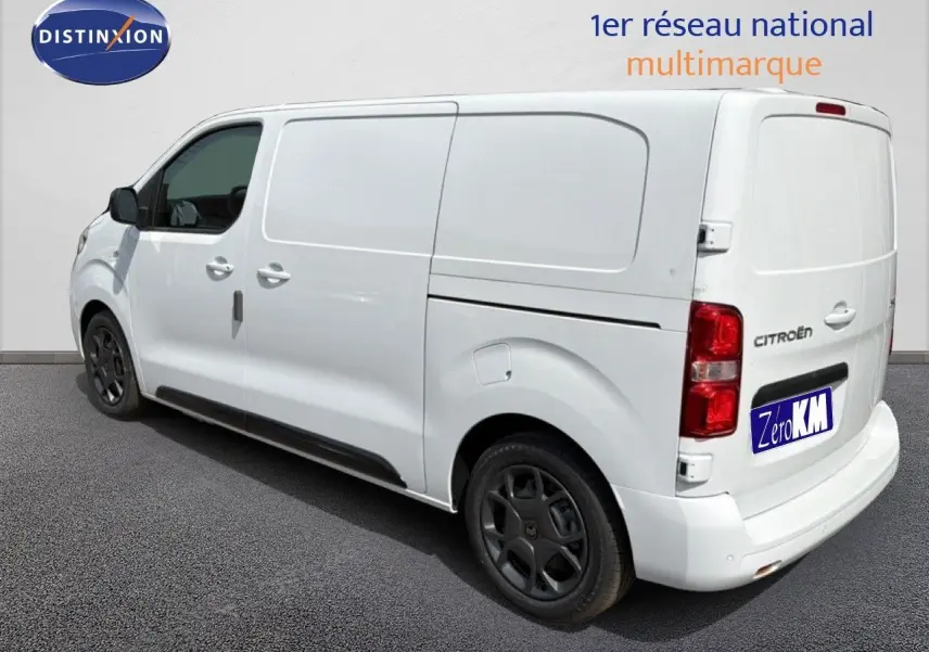 Vue 3/4 arrière droite d’un Citroën Jumpy blanc Kaolin avec jantes noires et porte latérale coulissante.