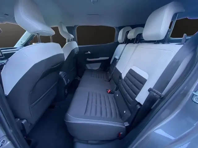Vue intérieure arrière de la Citroën C3 Hybrid 145 E-DCS6 MAX 2026, sièges arrière bicolores gris clair et foncé.
