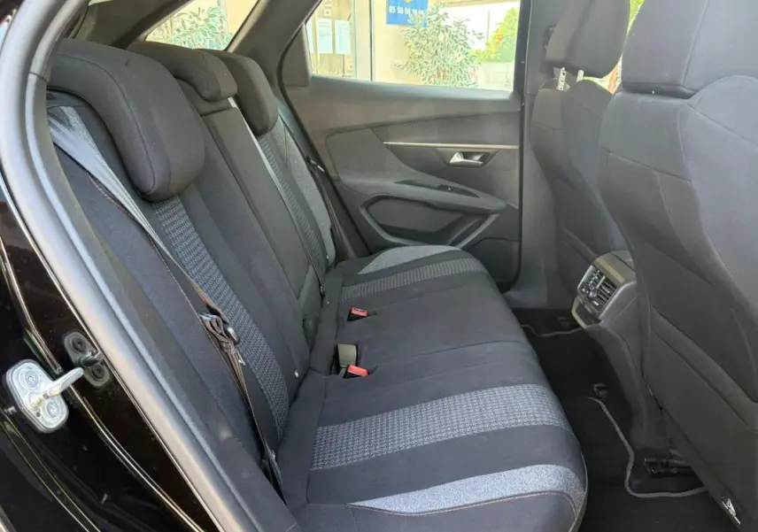 Vue intérieure côté gauche des sièges arrière noirs du Peugeot 3008 2021, montrant les ceintures et la porte ouverte.