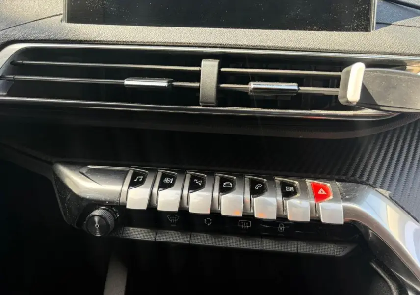 Détail de la console centrale avec les commandes piano chromées et la sortie d’air du Peugeot 3008 noir 2021.