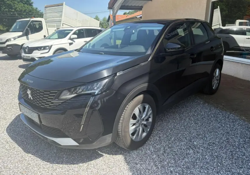 Peugeot 3008 noir vue 3/4 avant droit, avec calandre distinctive et jantes alliage, stationné sur gravier.