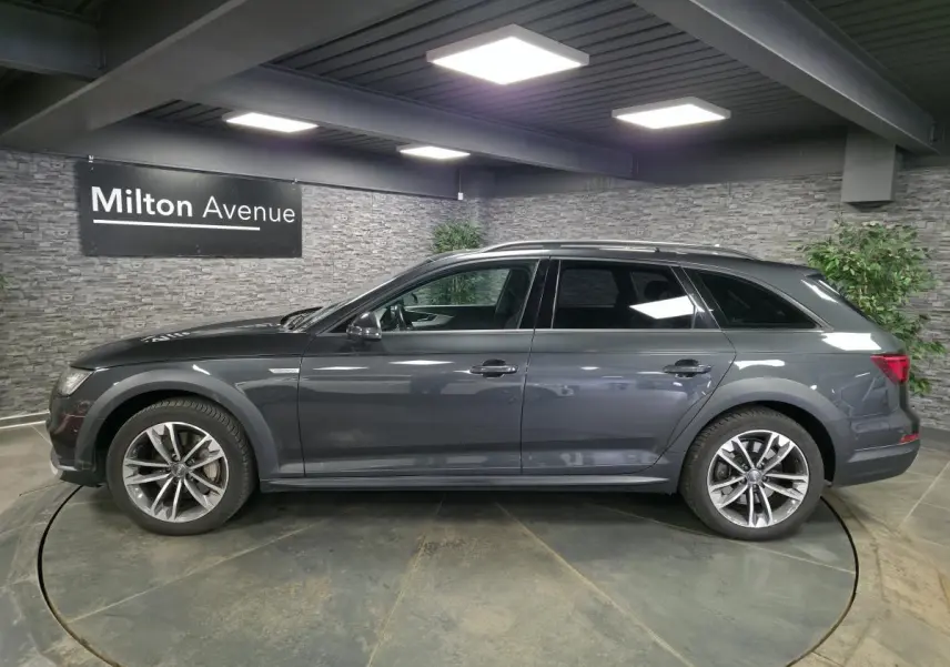 Audi A4 Allroad Quattro gris en profil droit, avec jantes aluminium 5 branches doubles et toit panoramique.