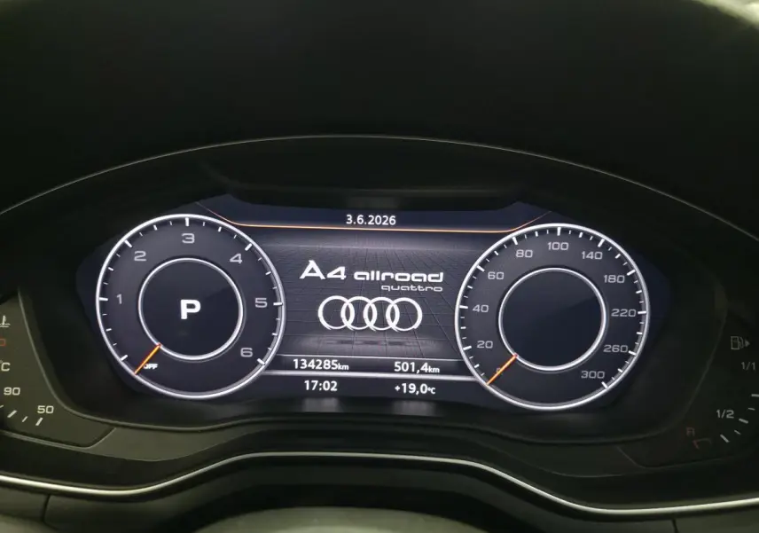 Vue rapprochée du tableau de bord numérique de l'Audi A4 Allroad gris, affichant compteurs et logo Quattro.