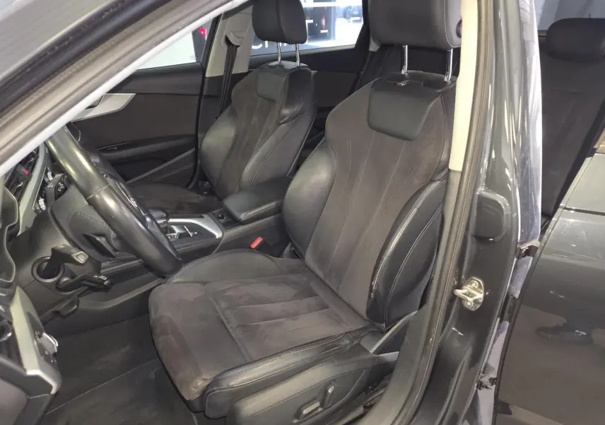 Vue intérieure côté conducteur de l'Audi A4 Allroad gris, mettant en valeur les sièges sport cuir/Alcantara et la console centrale.