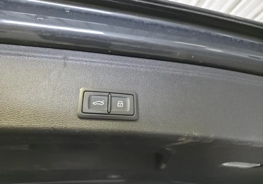 Boutons de commande pour ouverture et verrouillage du coffre sur le hayon intérieur d'une Audi A4 Allroad gris.