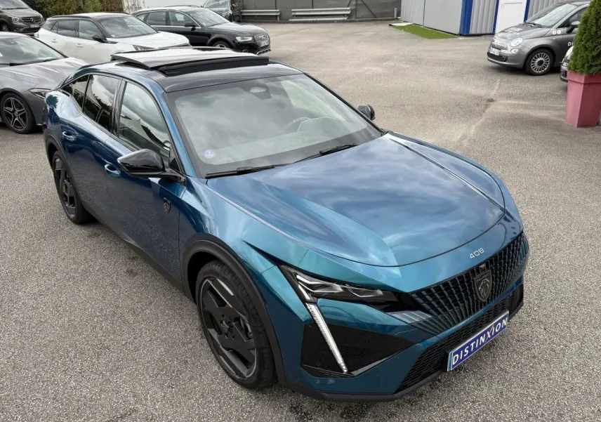 Peugeot 408 PHEV 225 GT bleu, vue 3/4 avant droit, avec calandre distinctive et phares LED en griffes.