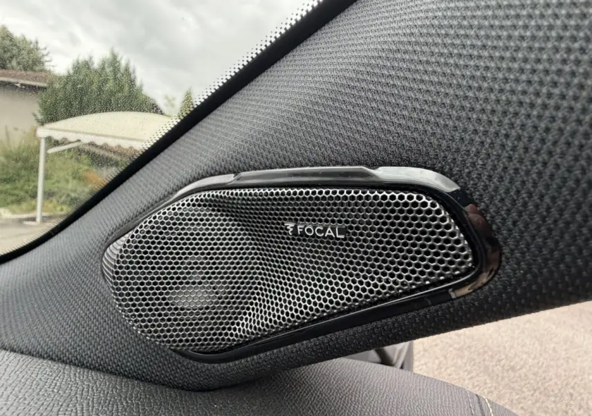 Gros plan sur l'enceinte Focal intégrée côté gauche dans l'habitacle d'une Peugeot 408 bleu 2023.