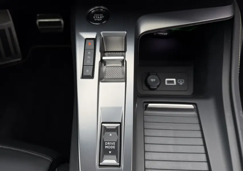 Vue rapprochée de la console centrale grise avec commandes Drive Mode et levier de vitesses sur Peugeot 408 PHEV 225 GT.