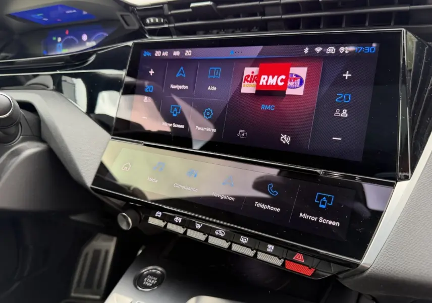Vue rapprochée de la console centrale tactile du Peugeot 408 PHEV 225 GT 2023, affichage multimédia et climatisation.