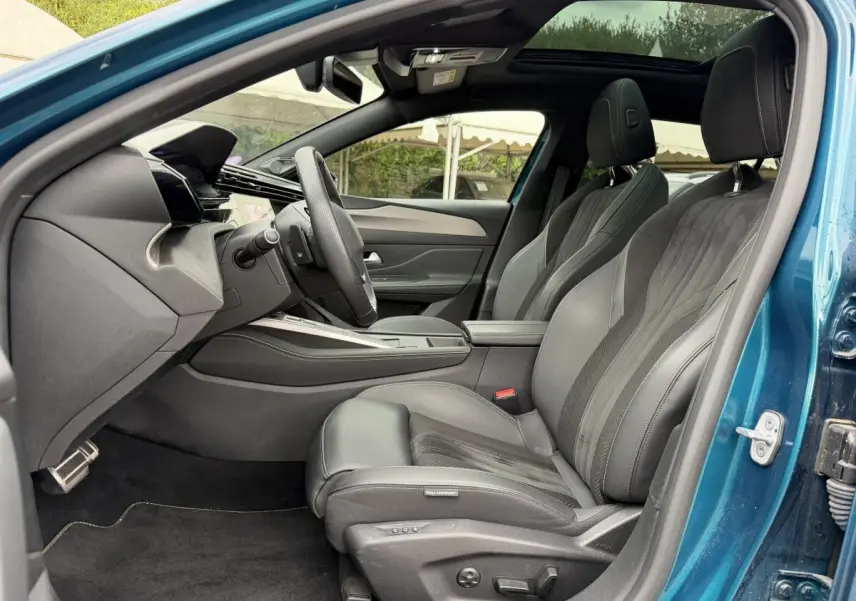Intérieur côté conducteur bleu Peugeot 408 PHEV 225 GT 2023, sièges cuir noirs et tableau de bord moderne.
